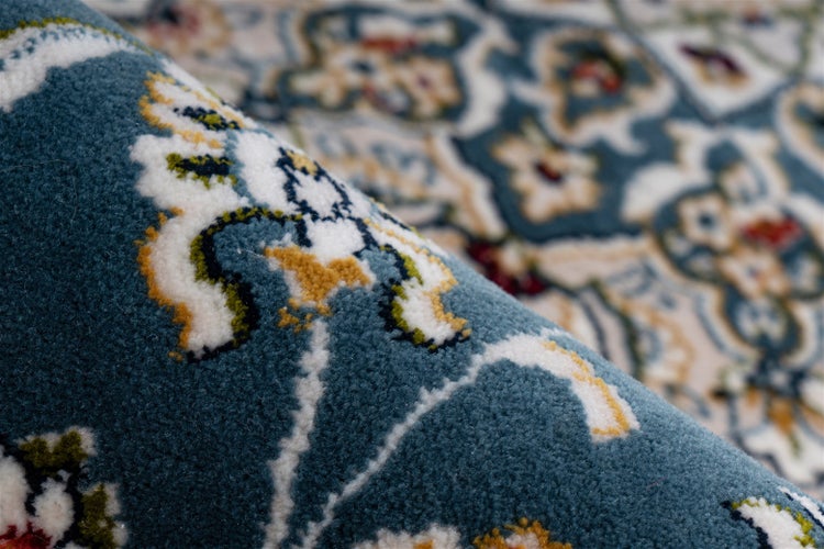 Detailaufnahme eines Teppichs mit orientalischem Blumenmuster und dichter Textur.