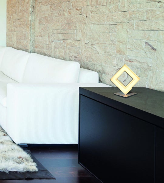 Wohnzimmer mit Sofa, Lowboard und dekorativer Lampe