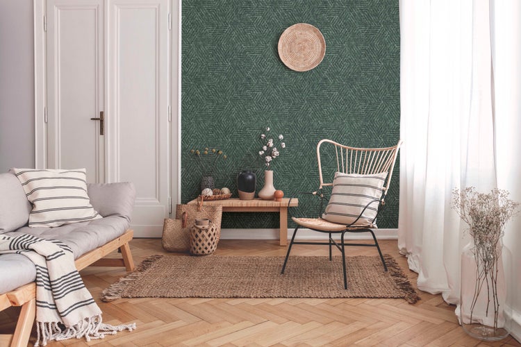 Schlafzimmer-Szene mit Bett, Nachttisch, Lampe und Zimmerpflanzen vor einer gemusterten Tapete
