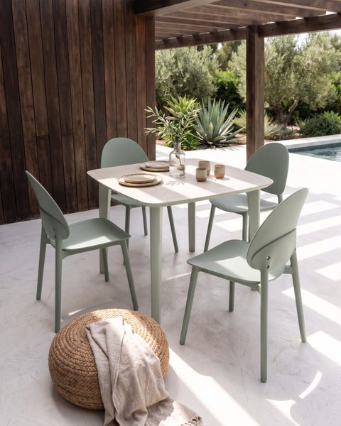 Modernes Gartenmöbel-Set mit quadratischem Tisch und vier Stühlen unter einer Holzpergola auf einer hellen, organisierten Terrasse am Pool.
