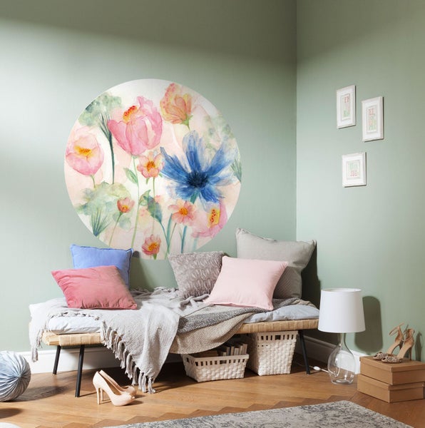 Wohnraum mit Blumenwandtattoo über einer Sitzbank mit Kissen und Decken