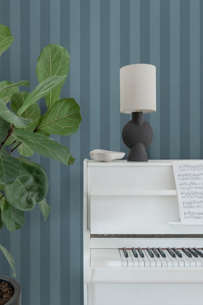 Raumansicht mit gestreifter Tapete in einem Schlafzimmer.