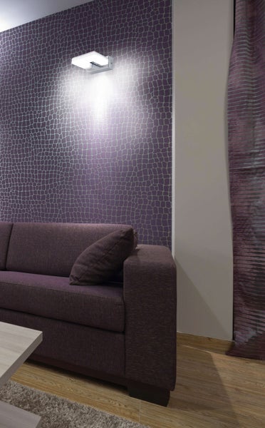 Wohnzimmer mit lila Tapete, Wandleuchte und Sofa