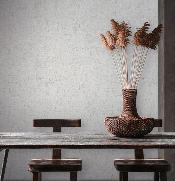 Wohnraum mit braunem Rattansessel, Holztisch, Dekoration, Teppich und Tapetenmuster