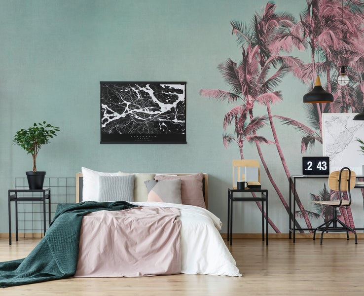 Modernes Schlafzimmer mit Palmen-Fototapete, Doppelbett mit Textilien, Stadtplan-Poster und einem integrierten Arbeitsbereich.