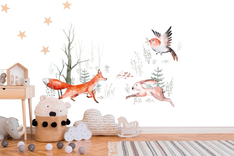 Wandtattoo Kinderzimmer Waldmotive Fuchs, Hase, Vogel, Bäume und Sterne im Aquarell-Stil über Holzmöbeln und Spielzeug.