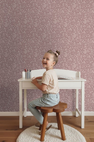 Vliestapete mit feinem floralem Muster im Kinderzimmer, kombiniert mit einem Schreibtisch und einem Hocker aus Holz.