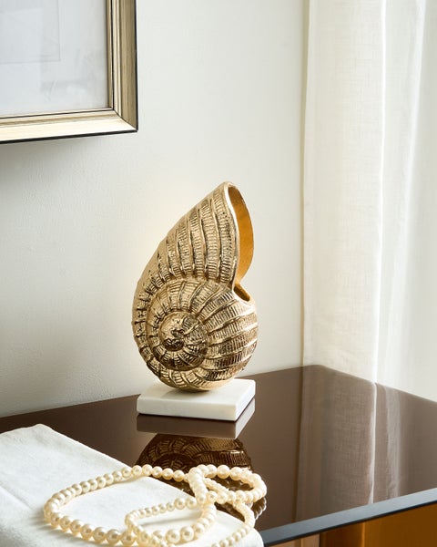 Dekorative goldfarbene Schnecke auf einem Tisch