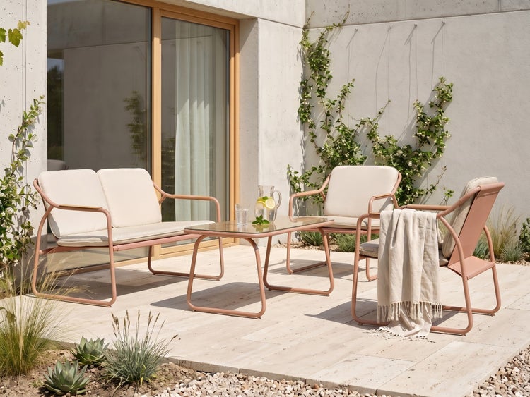Moderne Gartenlounge auf einer hellen Terrasse, bestehend aus einem Zweisitzer-Sofa, zwei Sesseln und einem Couchtisch mit Glasplatte.