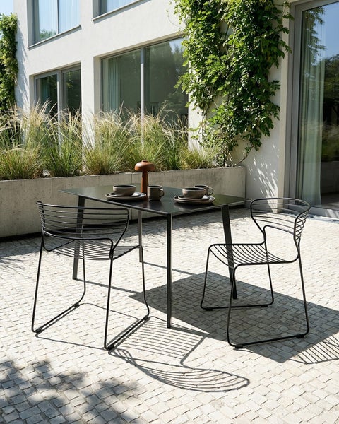 Quadratischer Gartentisch mit zwei Stühlen auf einer Terrasse