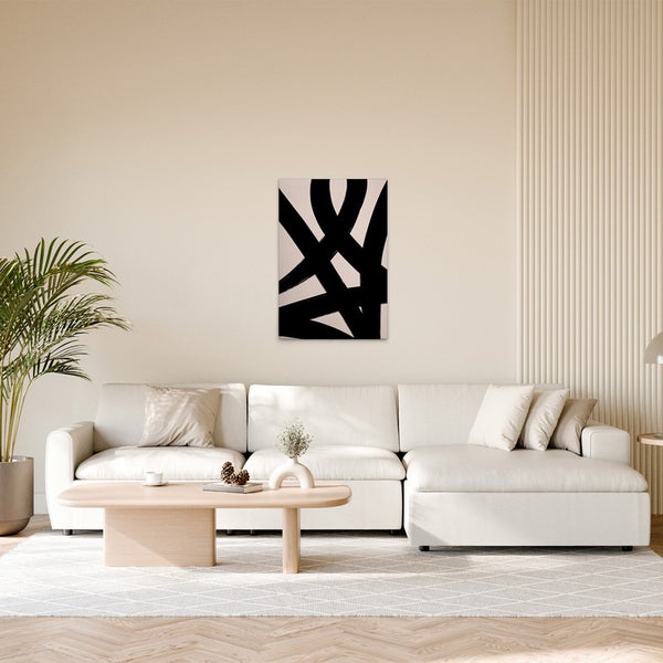 Wohnzimmer mit Sofa, Tisch und einem Wandbild mit abstrakten schwarzen Linien
