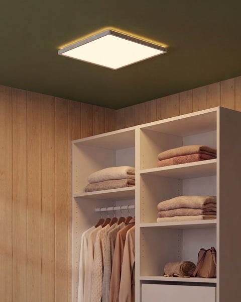 Quadratische LED Deckenleuchte in einem begehbaren Kleiderschrank mit Holzverkleidung und Kleiderregalsystem.