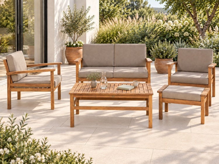 Gartenlounge Set aus Holz mit Tisch zwei Sesseln einem Sofa und einem Hocker inklusive Polsterauflagen auf einer Terrasse platziert.