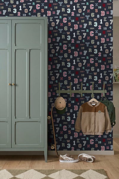 Tapete mit Buchstaben- und Zahlenmuster im College-Stil in einem Kinderzimmer neben einem Schrank und einer Garderobe.