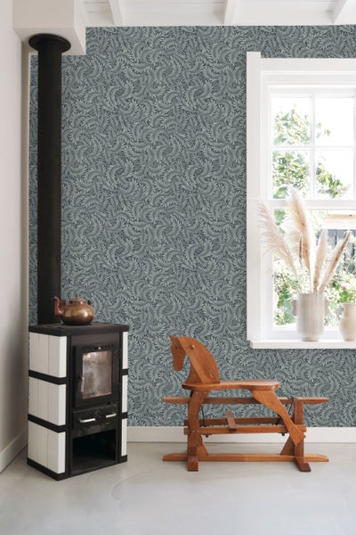 Raumansicht mit gemusterter Tapete, Kaminofen und Holzpferd