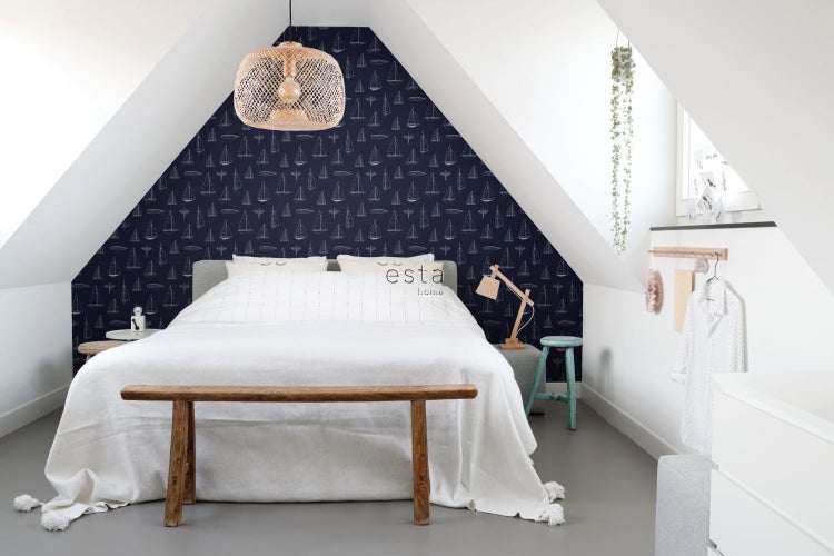 Schlafzimmer mit Bett, Bank, Lampe und Tapete mit Segelbootmuster