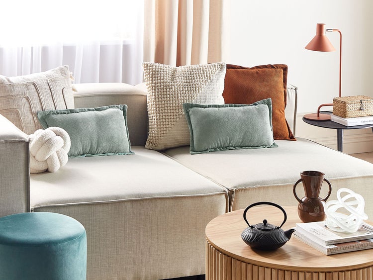 Wohnzimmer mit Sofa, Kissen, Tisch und Dekoration