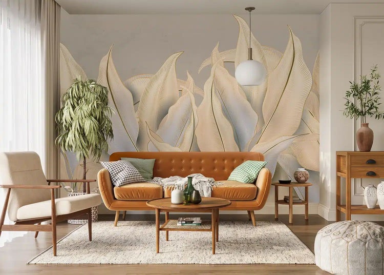 Wohnzimmer mit großformatiger Fototapete mit Blattmotiven, cognacfarbenem Sofa, Holzmöbeln und Zimmerpflanzen.