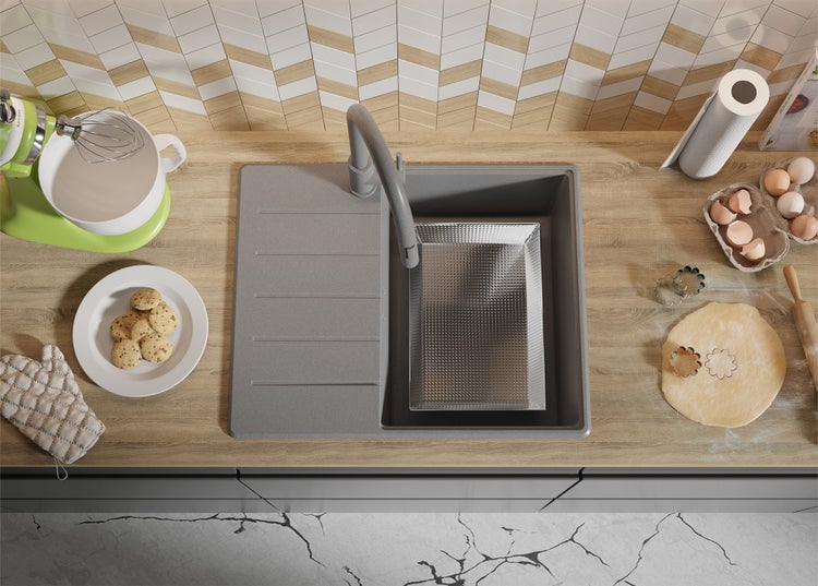 Küchenszene mit Spüle, Armatur und verschiedenen Küchenutensilien auf einer Arbeitsplatte.