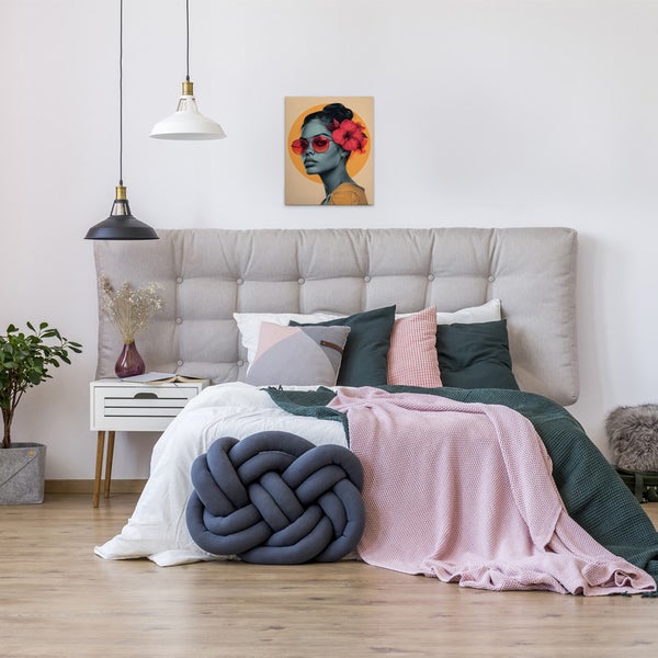 Schlafzimmer mit Bett, Nachttisch, Lampen und einem Wandbild einer Frau mit Sonnenbrille und Blumen