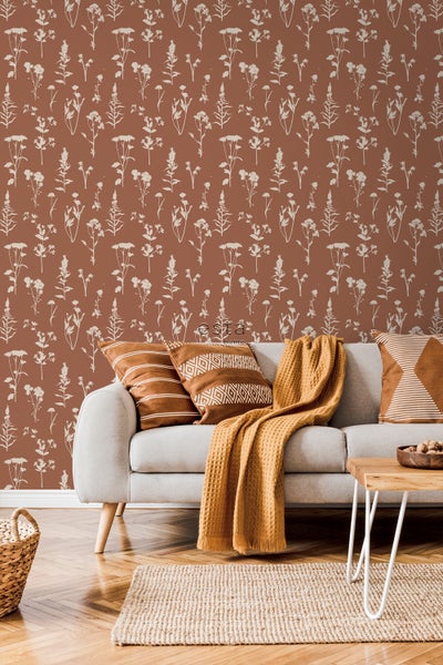 Wohnzimmer mit gemusterter Tapete, Sofa, Kissen und Teppich.