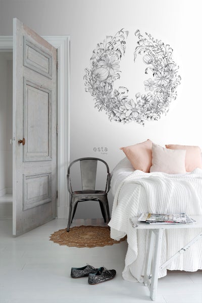 Helles Schlafzimmer mit Bett, Stuhl, Wandtattoo und offener Tür