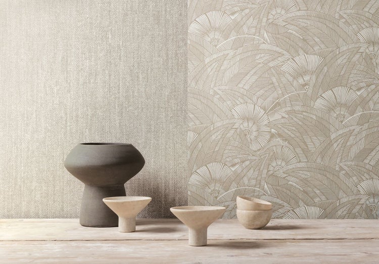 Dekorative Szene mit verschiedenen Tapetenmustern und dekorativen Vasen auf einem Holztisch.