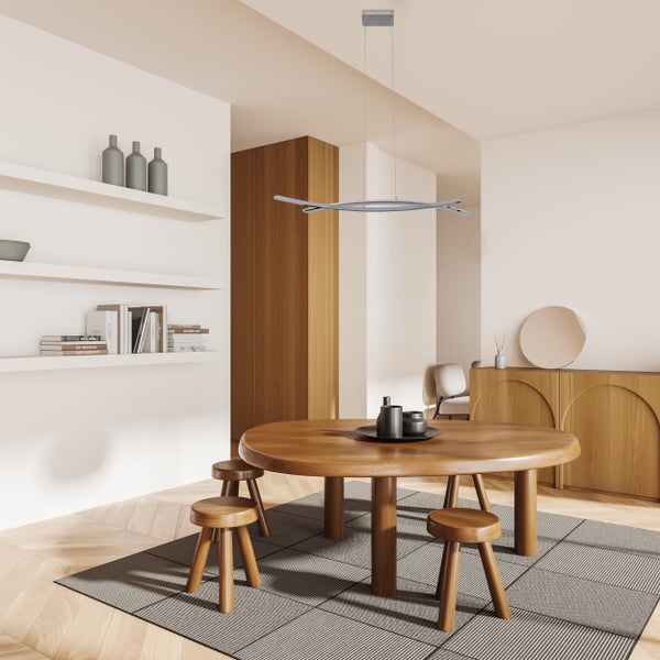 Heller Wohnraum mit rundem Holztisch, Holzstühlen, Teppich und moderner Hängelampe.