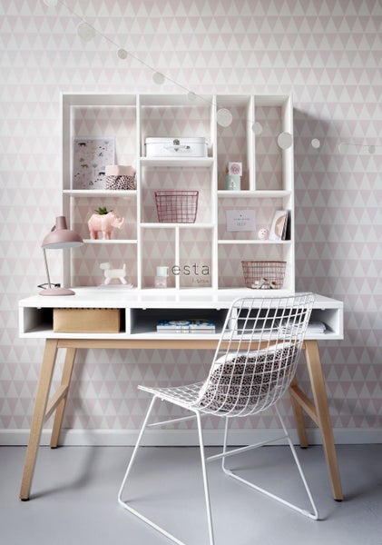 Kinderzimmer mit weißem Schreibtisch, Regalelementen und einem Stuhl mit Gitterdesign vor einer dreieckigen Tapete.