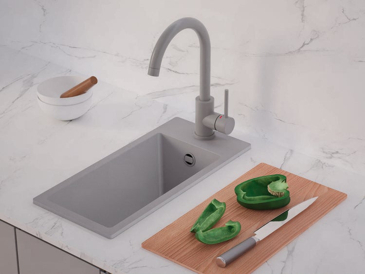 Moderne Küchenspüle mit Einbaubecken und hohem Auslauf-Wasserhahn auf einer Arbeitsplatte in Marmor-Optik mit Schneidebrett und Gemüse.