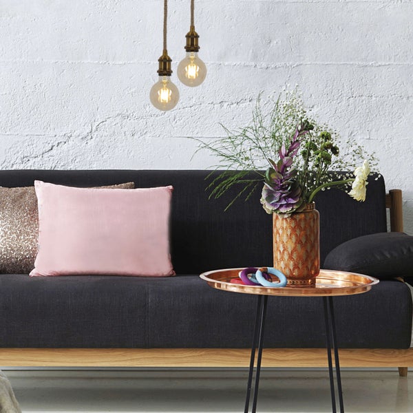 Wohnzimmer-Szene mit Sessel, Beistelltisch und Hängelampen.