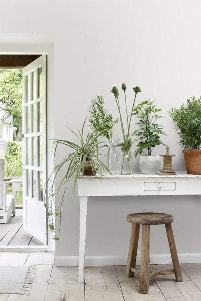 Helle Einrichtung mit Tisch, Pflanzen und Dekoration