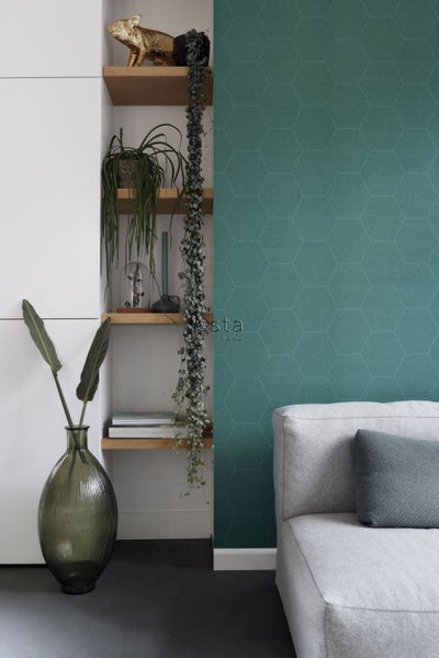 Wohnzimmer mit grüner gemusterter Tapete, Regal und grauer Couch