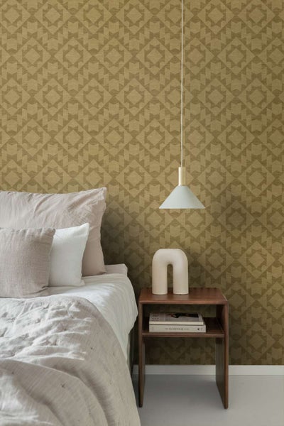 Ein Schlafzimmer mit einer Mustertapete mit geometrischem Design, einem Nachttisch aus Holz, einer Hängelampe und einem Bett mit Kissen.