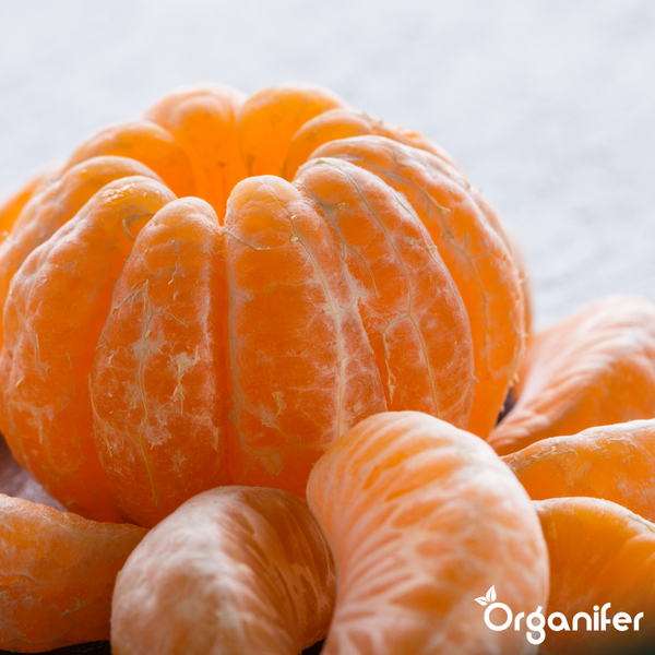 Geschälte Mandarine und Mandarinensegmente mit Organifer Logo.