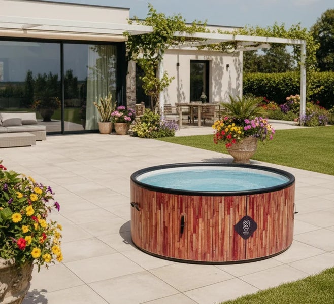 Aufblasbarer Whirlpool in Holzoptik auf einer hellen Fliesenterrasse in einem modernen, hellen Garten mit Haus im Hintergrund.