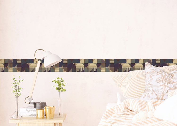 Helles Wohnzimmer mit beigefarbenem Sofa, Holztischen und einer geometrischen Tapetenbordüre mit Halbkreis-Muster an der Wand.