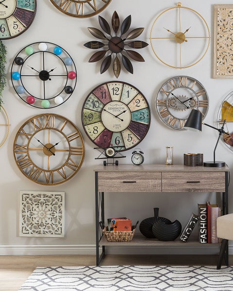 Wand mit einer Sammlung von dekorativen Uhren und einem Konsolentisch mit Dekorationsartikeln