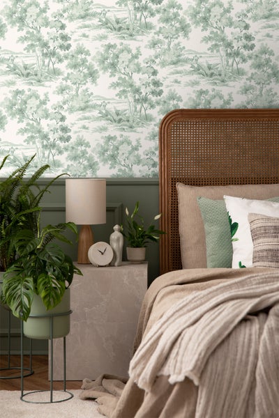 Schlafzimmer mit grüner Waldtapete und Holzbettrahmen