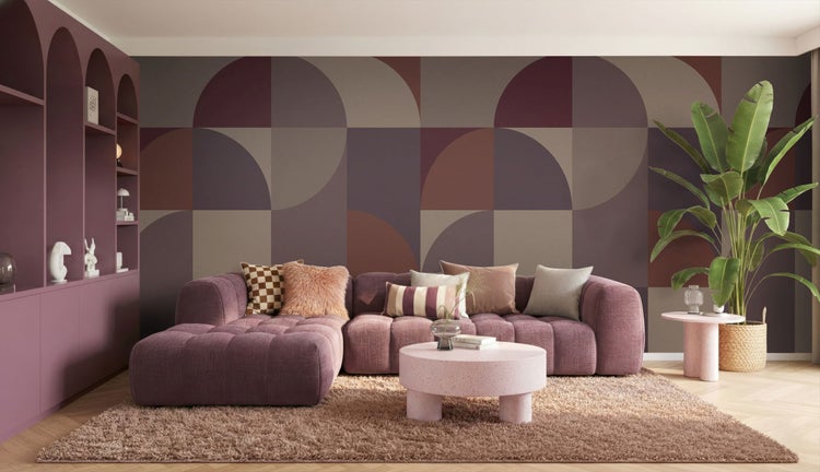 Wohnzimmer mit modularem Sofa, Teppich, Couchtisch, Zimmerpflanze, Regal und geometrischer Tapete