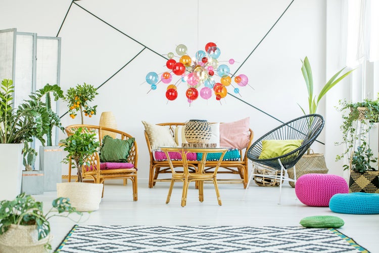 Helle, freundliche Wohnung mit Rattanmöbeln, bunten Akzenten und Zimmerpflanzen