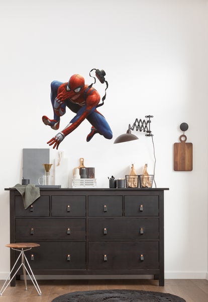 Dekoratives Zimmer mit Kommode, Wandlampe und Spiderman Wandtattoo