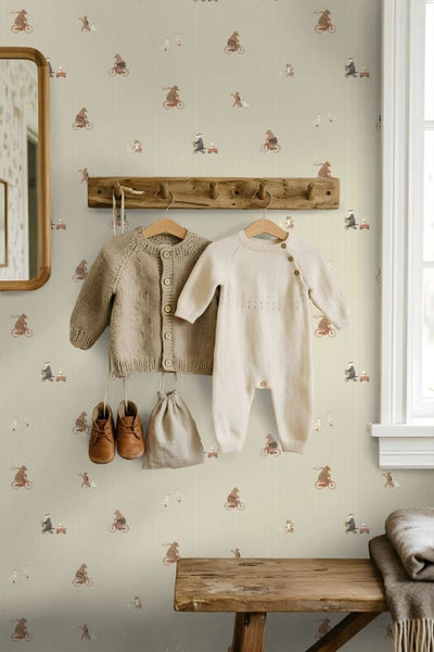 Kindertapete mit Tiermotiven an einer Wand mit Garderobe und Babykleidung