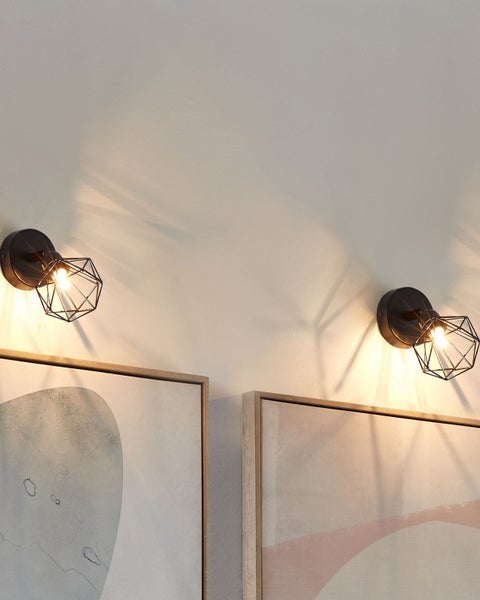 Zwei Wandleuchten aus Metall in Schwarz mit einem geometrischen Schirm in Diamantform.