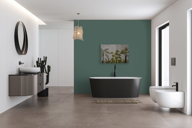 Modernes Badezimmer mit freistehender Badewanne, wandhängendem Waschbecken, hängendem WC und Bidet in einem geräumigen Raum mit grüner Akzentwand.