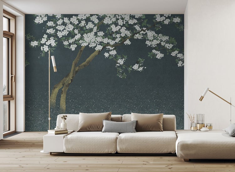 Wohnzimmer mit Sofa und einer Wandtapete mit einem Baum mit weißen Blüten