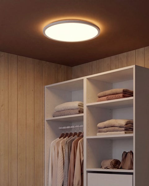 Runde LED Deckenleuchte in einem begehbaren Kleiderschrank mit hellen Regalen und Holzverkleidung an den Wänden
