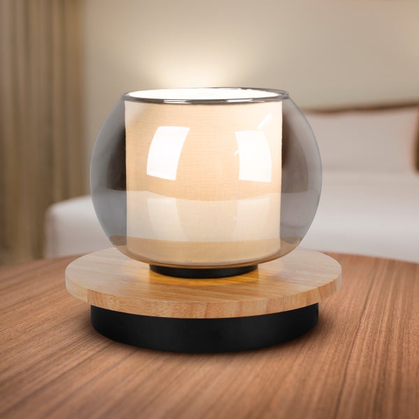 Dekorative Tischleuchte mit Stoffschirm und Holzfuß auf einem Tisch