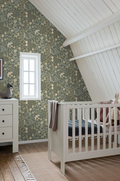 Kinderzimmer mit floraler Tapete, Babybett und Kommode.