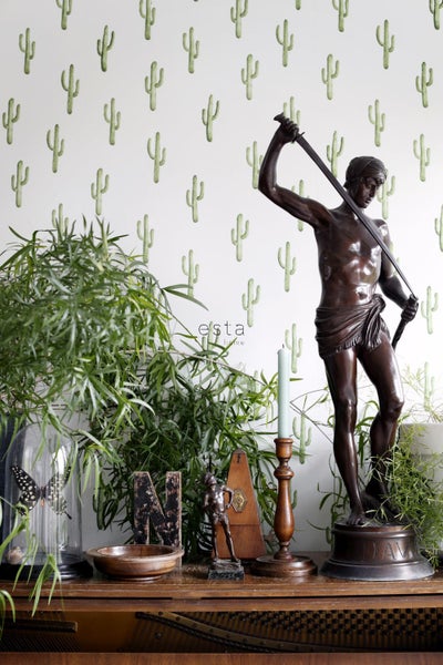 Dekoratives Interieur mit Kaktusmuster-Tapete, Statue und Pflanzen